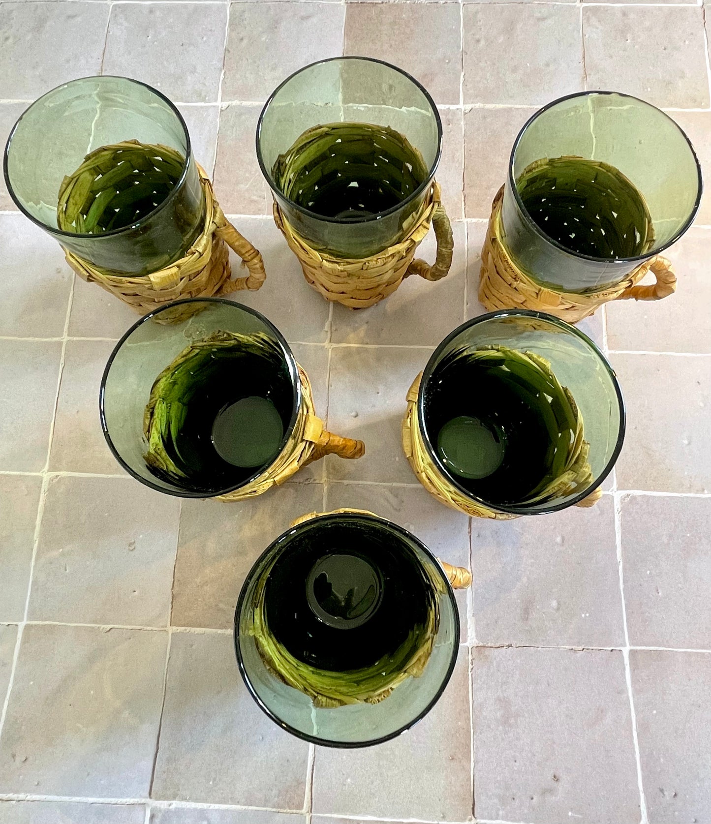6 70s glasses presented in their woven wicker glass holders.