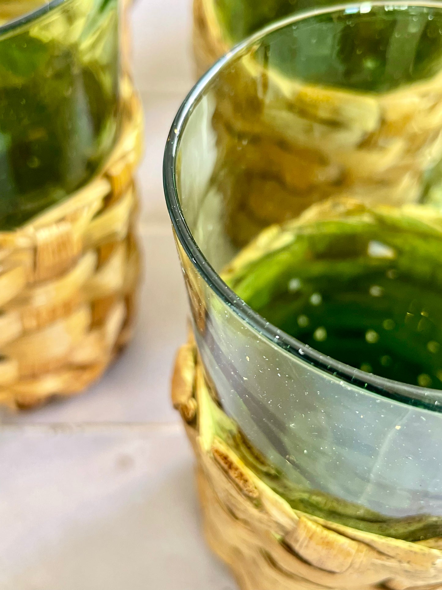 6 70s glasses presented in their woven wicker glass holders.